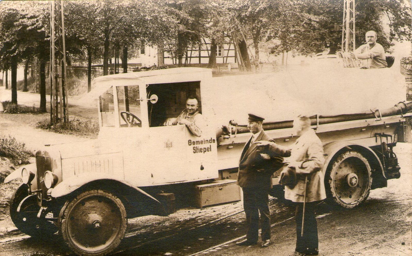 "Minister" Friedrich Finke (mit Kappe) vor dem Stiepeler Sprengwagen. Am Steuer: Otto Bierwirth. Aufgenommen auf der Kreuzung der heutigen Kemnader- mit Koster- und Haarstraße. Im Hintergrund das Fachwerkhaus neben dem heutigen Hof Schulte-Schüren.